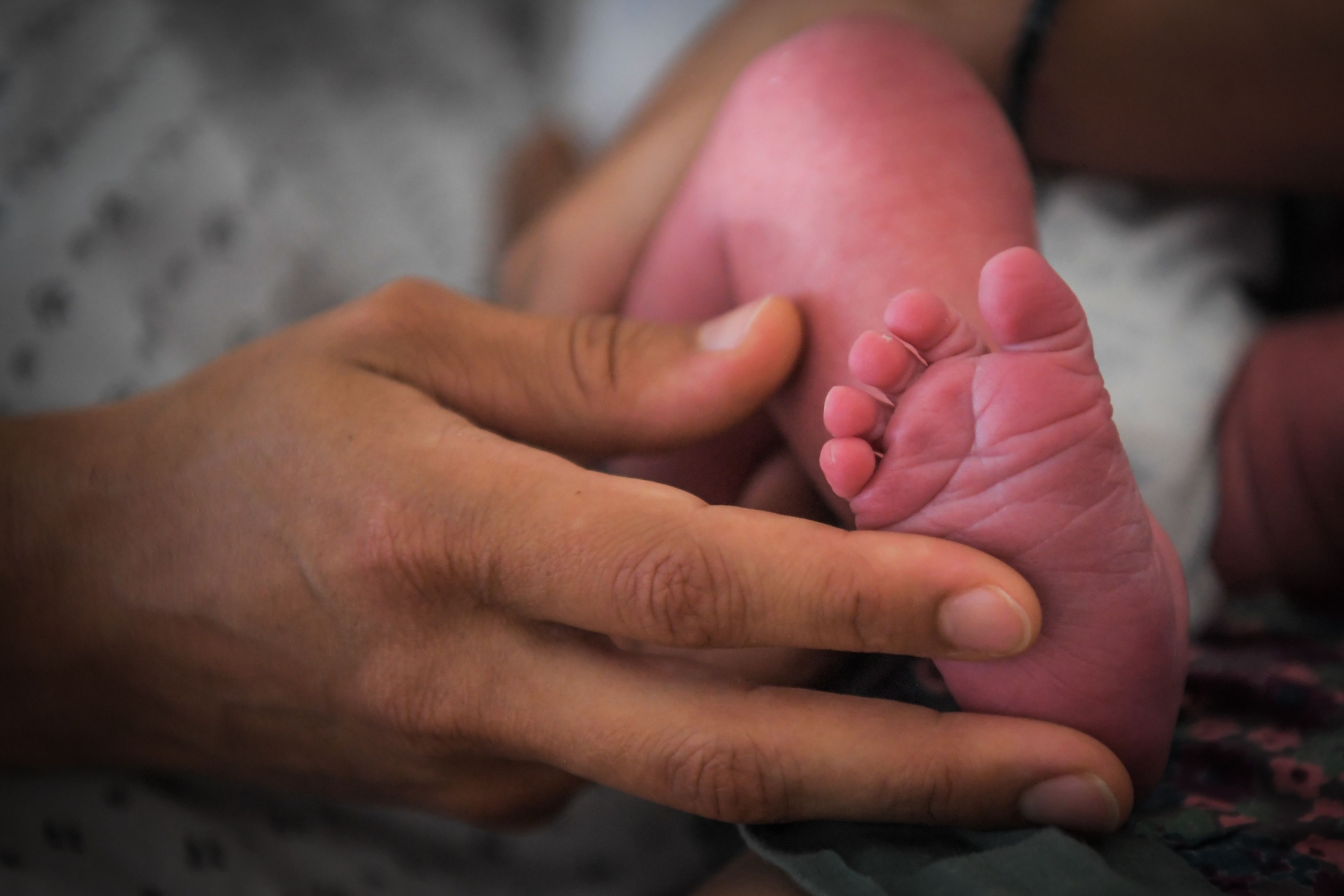 A mother holds the foot of her newborn baby on July 7, 2018 at the hospital in Nantes, western France. (Photo by LOIC VENANCE / AFP)        (Photo credit should read LOIC VENANCE/AFP via Getty Images)