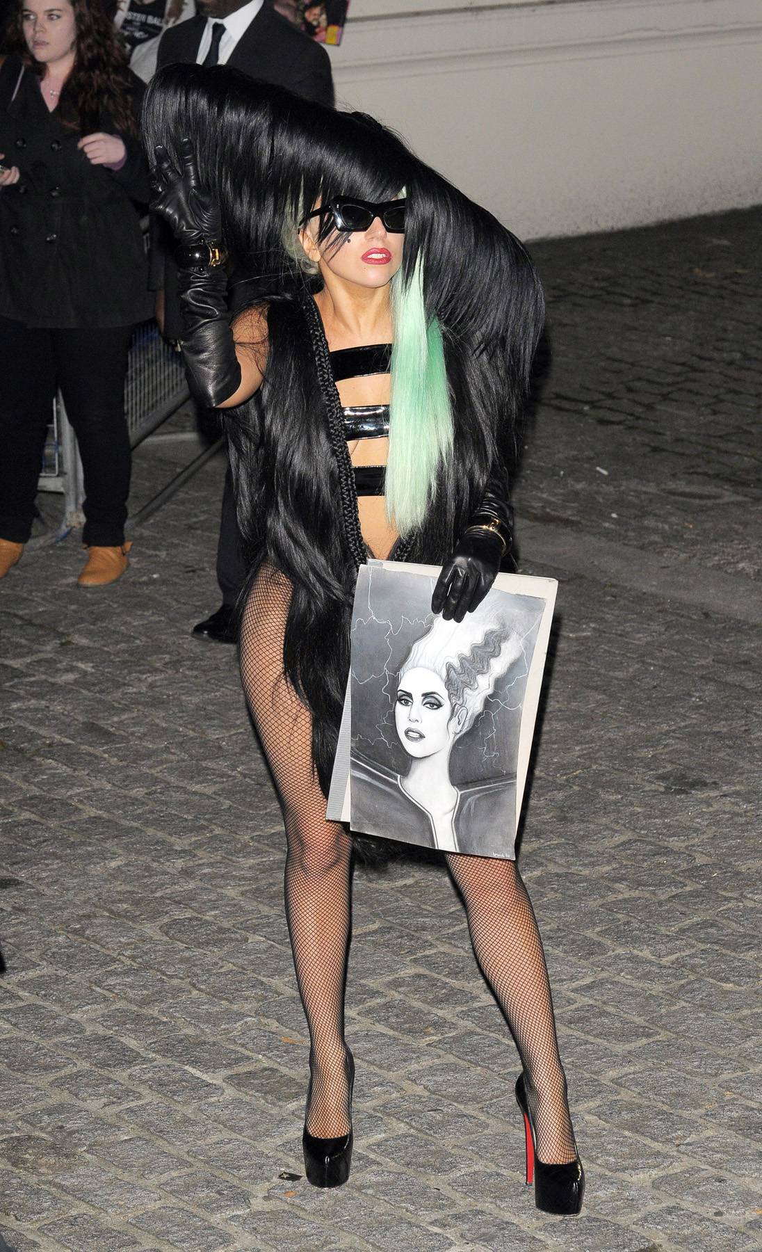 Hair Everywhere\r - Lady Gaga in a long-haired leotard and matching oversized hat is seen leaving her hotel holding a picture of herself as the bride of Frankenstein drawn by a fan in the streets of London. (Photo: FamePictures)