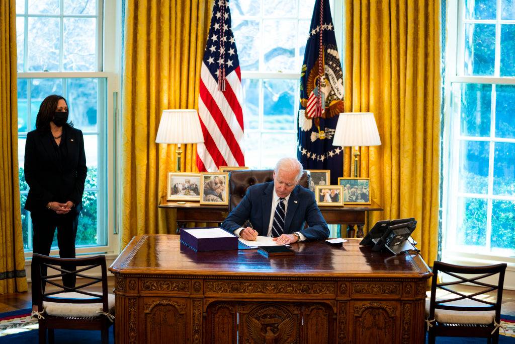 President Joe Biden signs the American Rescue Plan with Vice President Kamala Harris looking on in the Oval Office, Thursday, March, 11, 2021.  (Photo by Doug Mills/The New York Times)