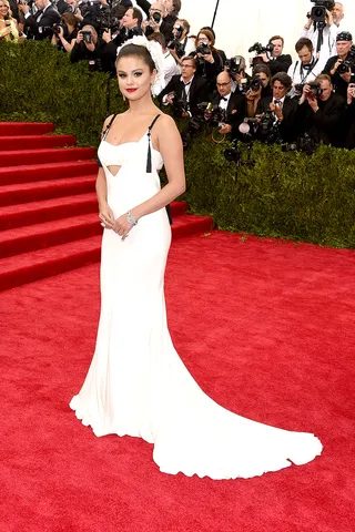 Selena Gomez - The pop star shines in a plunging white Vera Wang gown with tassel details. Her updo is finished beautifully into a halo of white blossoms.  (Photo: Larry Busacca/Getty Images)