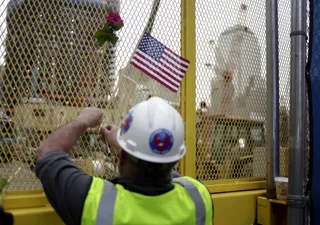 Ground Zero - A construction worker affixes an American flag to a fence at Ground Zero.(Photo: AP Photo/Seth Wenig)