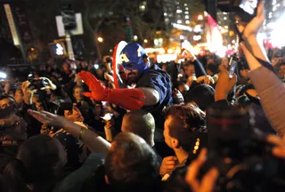Captain America Arrives - A reveler dressed as Captain America celebrates near Ground Zero in New York.(Photo: AP Photo/Jason DeCrow)