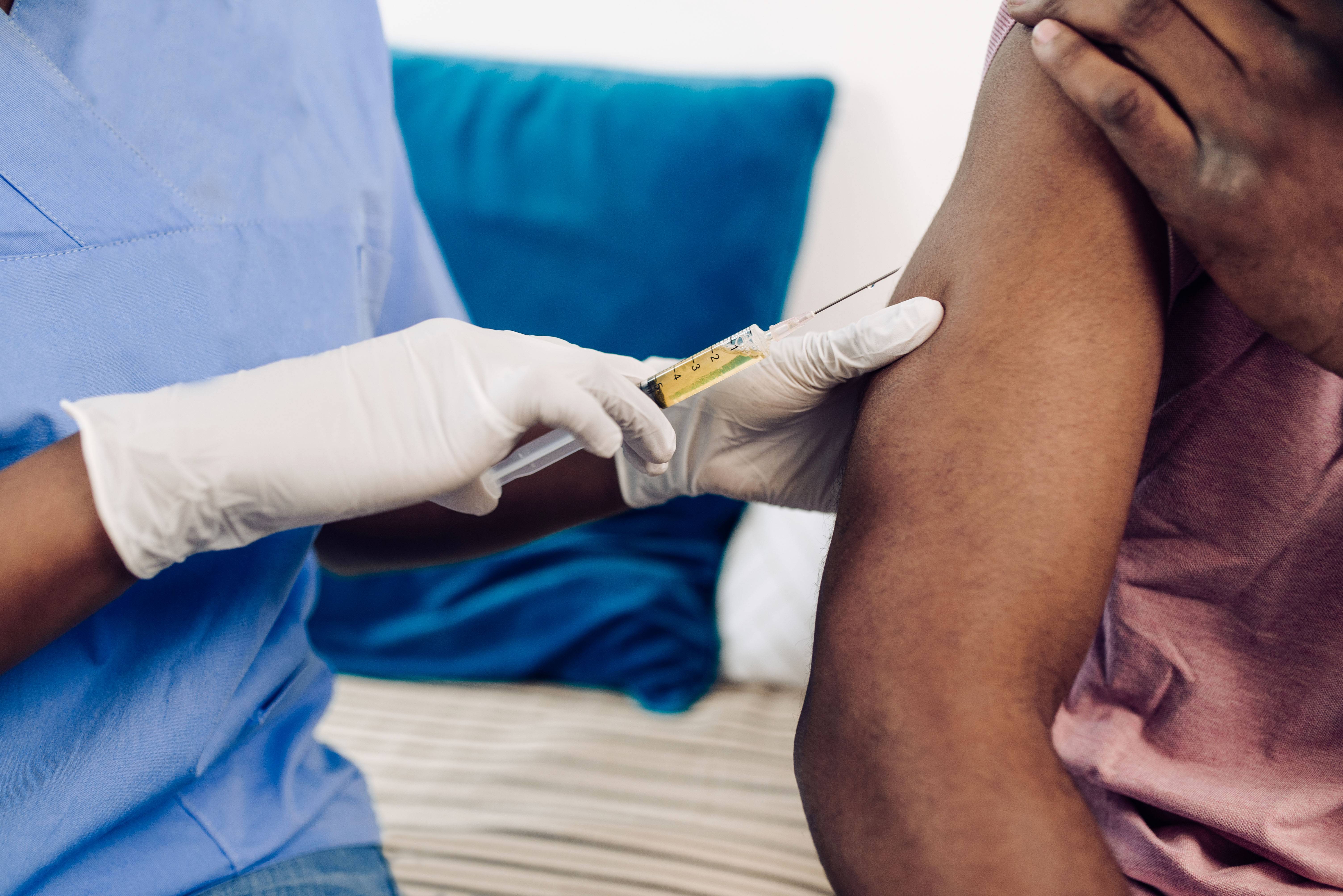 Unrecognizable African American young man receiving a Covid-19 vaccine.