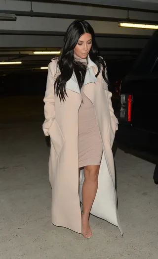 Nude Ambition - The reality TV star dashes through London in a monochromatic ensemble of soft shades of nude. She teams her Spring 2015 Balenciaga crepe trench coat over a fitted mock neck dress and her favorite heels.   (Photo: © Palace Lee, PacificCoastNews)