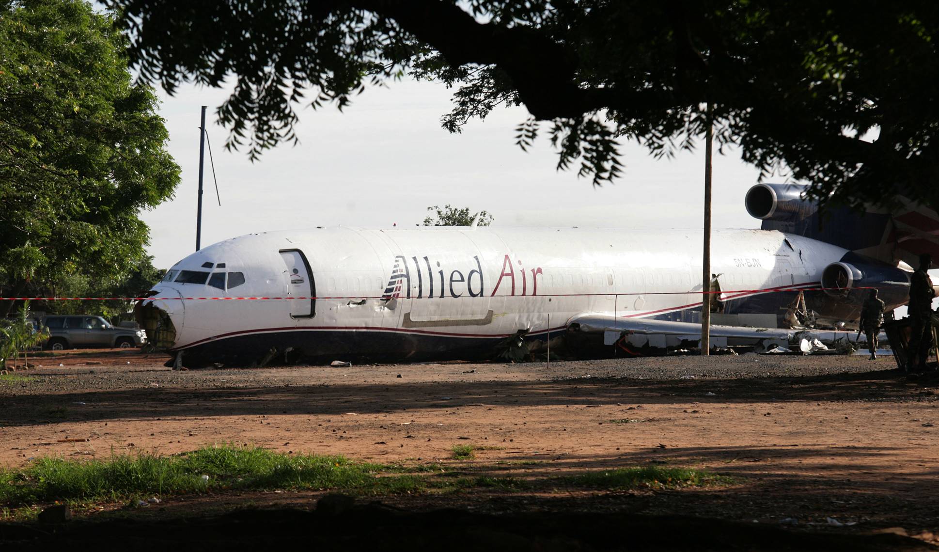 Investigation Starts on Cargo Plane Crash in Ghana - Officials opened an investigation into the Boeing 727 cargo plane that crashed at Ghana's international airport killing at least 10 people after it slammed through a fence and onto a nearby street, the country's transit company said Sunday.(Photo: AP Photo/Christian Thompson)