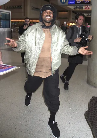 A Rare Sight - Kanye West was spotted smiling from ear to ear as he caught his flight out of Los Angeles.(Photo: Sharky / Splash News)