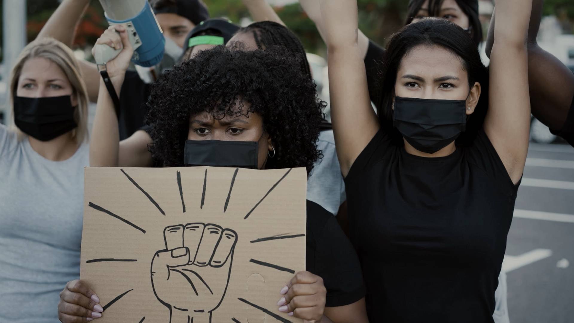 Protesters with their hands up and holding signs.