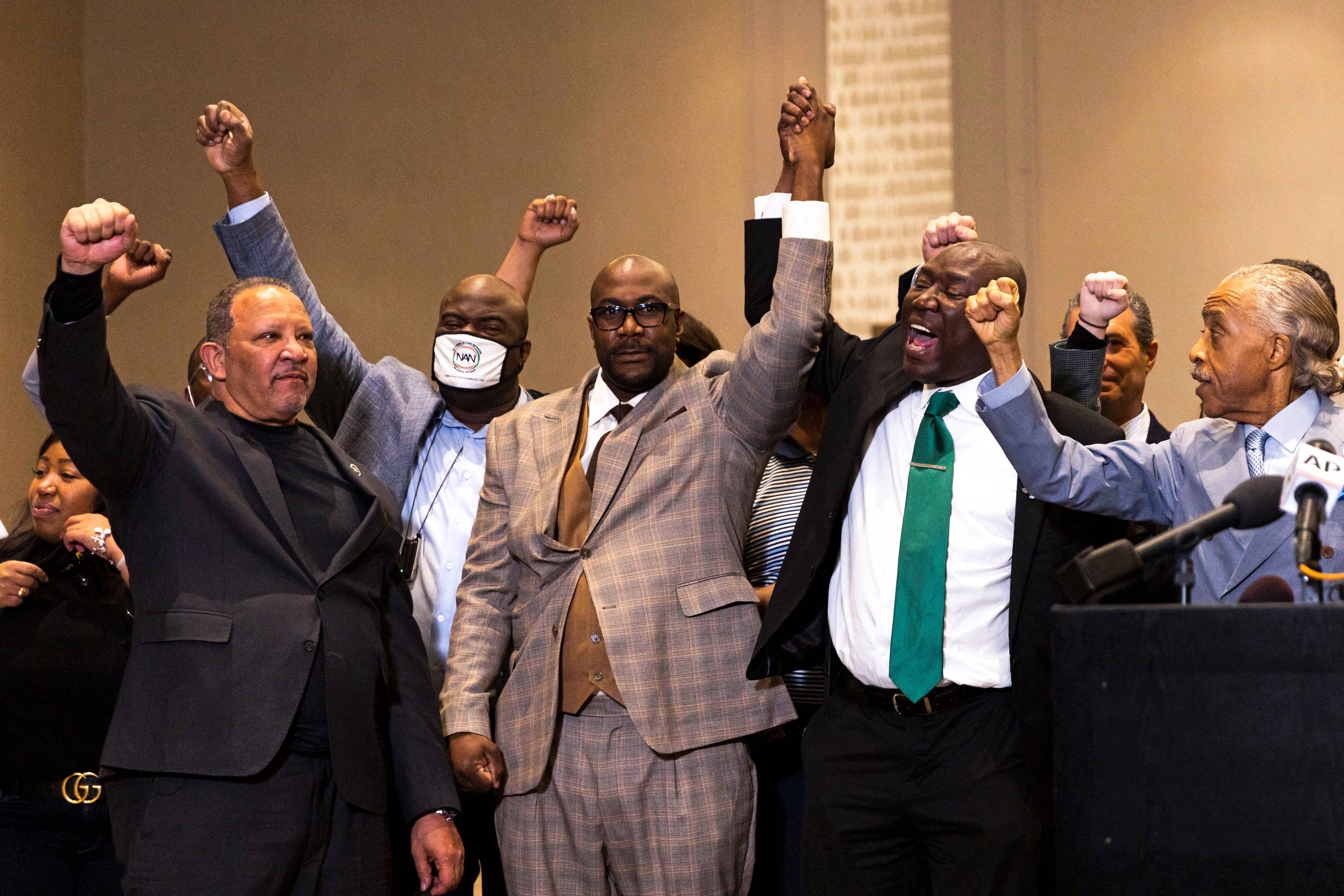 George Floyd's brother Philonise Floyd (C), flanked by Reverend Al Sharpton (2nd L) and Attorney Ben Crump (R), hold up their arms during a press conference following the verdict in the trial of former police officer Derek Chauvin in Minneapolis, Minnesota on April 20, 2021. - Sacked police officer Derek Chauvin was convicted of murder and manslaughter on april 20 in the death of African-American George Floyd in a case that roiled the United States for almost a year, laying bare deep racial divisions. (Photo by Kerem Yucel / AFP) (Photo by KEREM YUCEL/AFP via Getty Images)