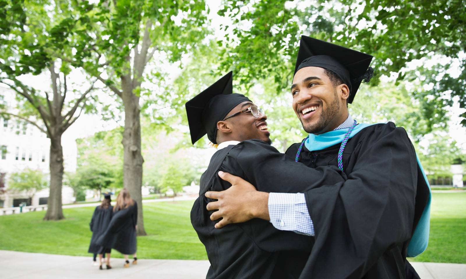 College graduates hugging Camille Tokerud