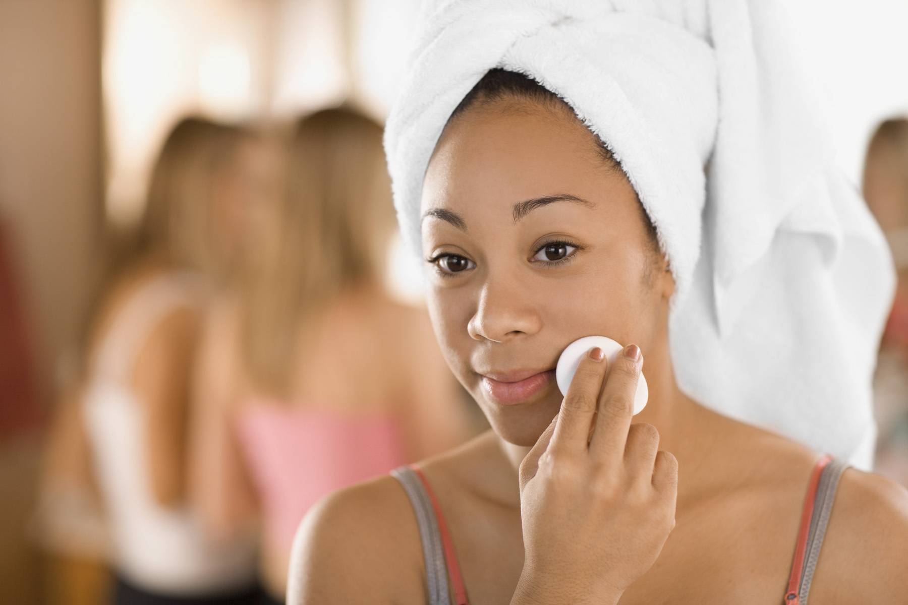 woman removing makeup from her face