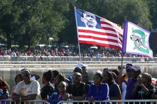 Flags Symbolizing Progress - People waved flags that symbolized progress. A marcher holds up a unique American flag that has an image of President Obama. (Photo: Mark Wilson/Getty Images)