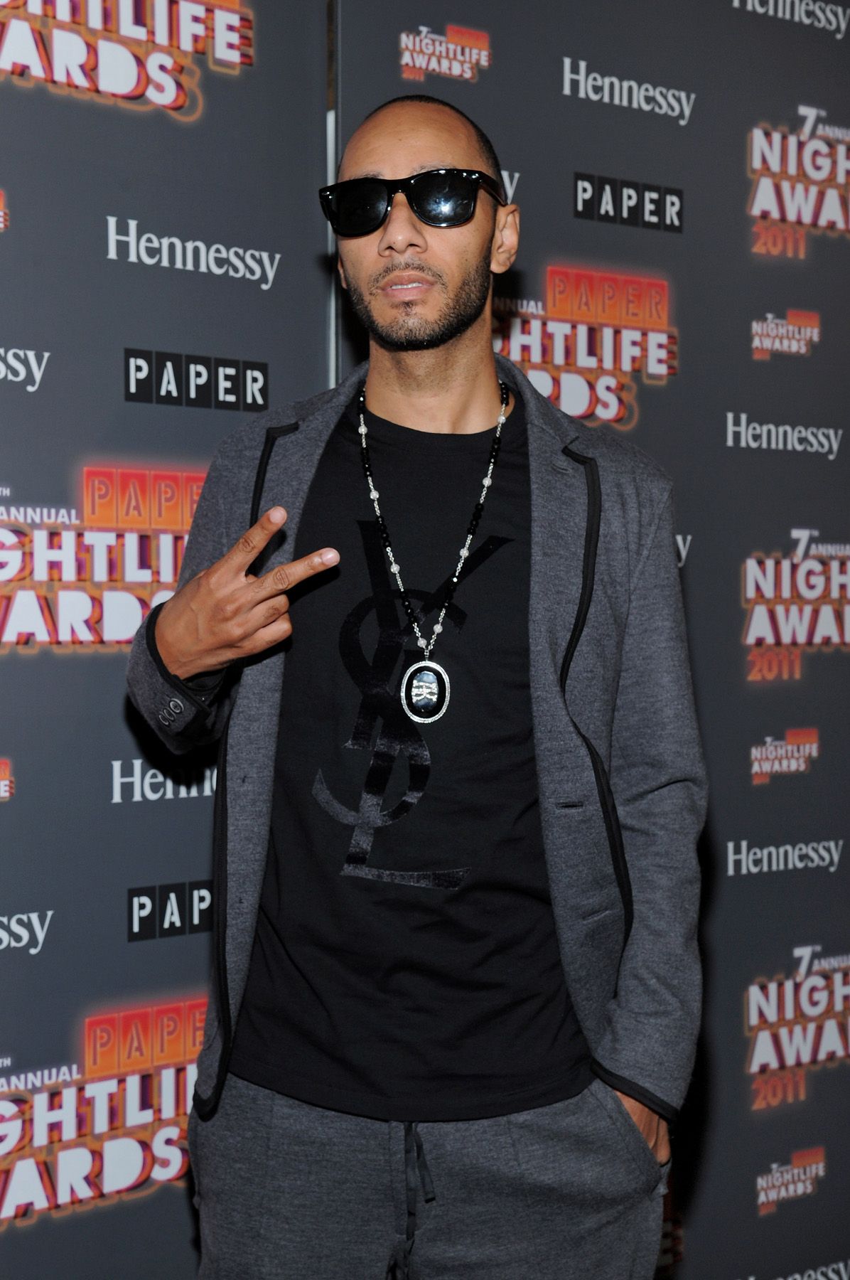 Stay Black\r - Producer Swizz Beatz shows up in black shades, a gray tuxedo with a black-on-black YSL tee on the black carpet of the Paper Magazine 2011 Nightlife Awards at Hiro Ballroom at The Maritime Hotel&nbsp;in New York City. Can you say "too cool for school"? (Photo by Mike Coppola/Getty Images)