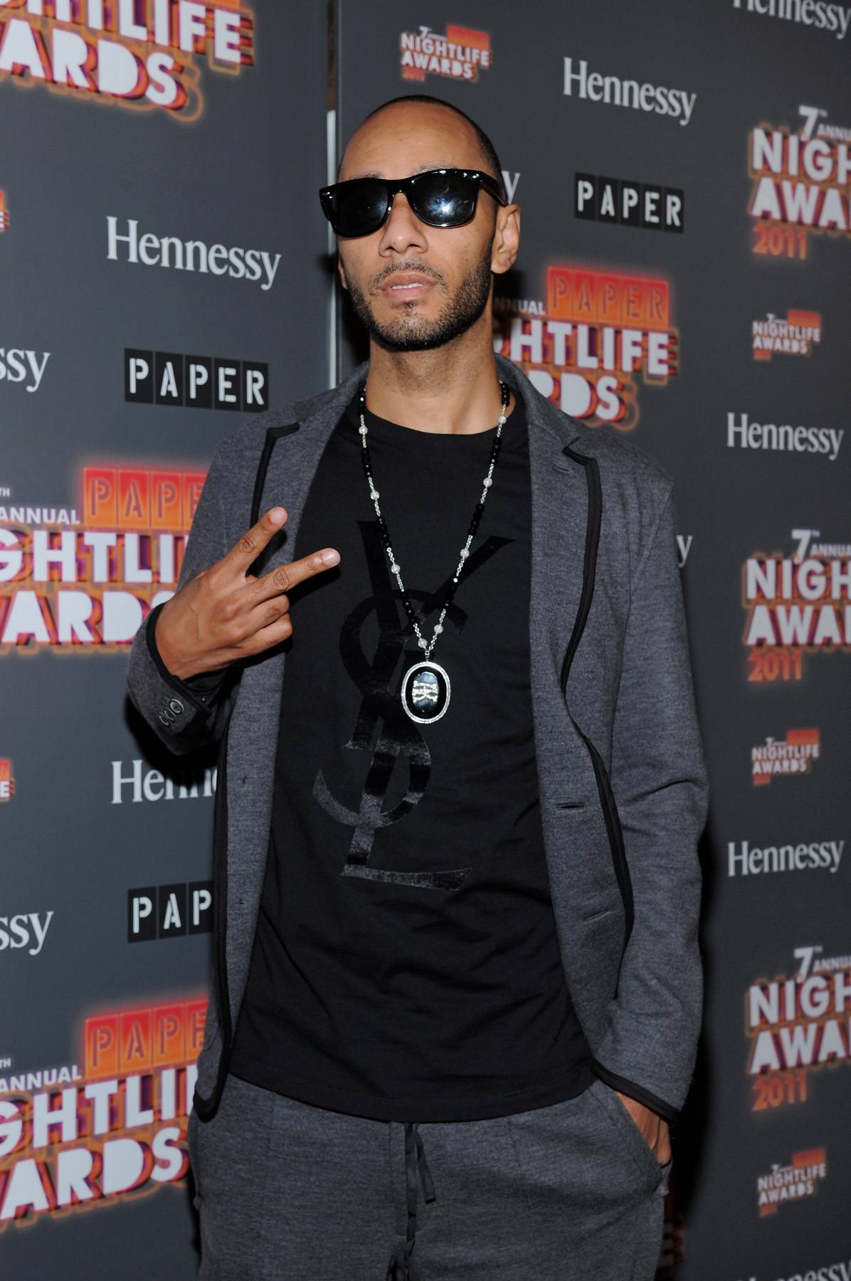 Stay Black\r - Producer Swizz Beatz shows up in black shades, a gray tuxedo with a black-on-black YSL tee on the black carpet of the Paper Magazine 2011 Nightlife Awards at Hiro Ballroom at The Maritime Hotel&nbsp;in New York City. Can you say &quot;too cool for school&quot;? (Photo by Mike Coppola/Getty Images)