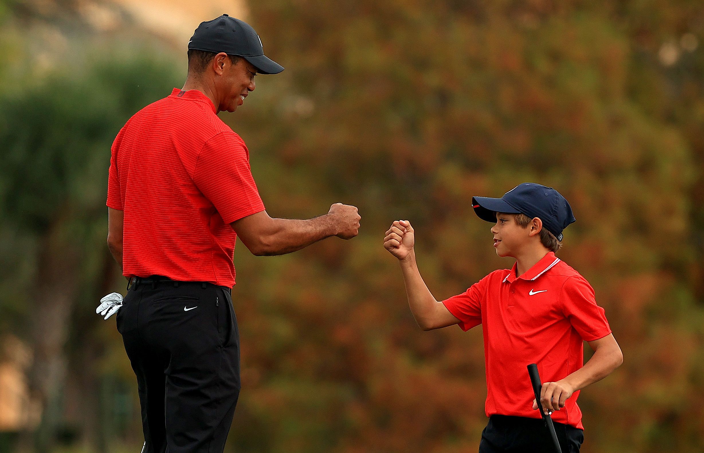 ORLANDO, FLORIDA - DECEMBER 20: Tiger Woods of the United States and son Charlie Woods fist bump on the 18th hole during the final round of the PNC Championship at the Ritz Carlton Golf Club on December 20, 2020 in Orlando, Florida. (Photo by Mike Ehrmann/Getty Images)