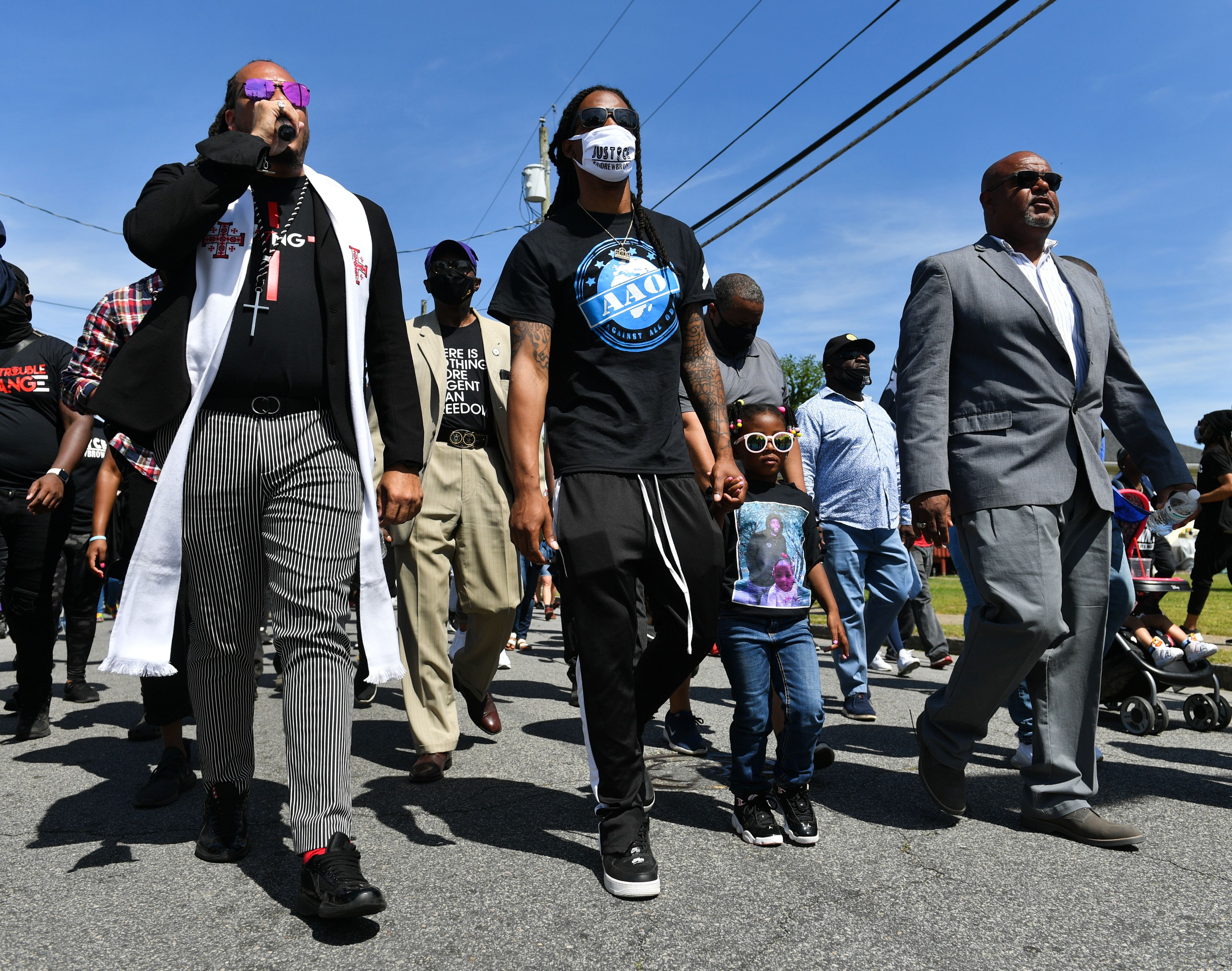 NORTH CAROLINA, USA - MAY 02: Reverend Greg Drumwright (R) leads a march as Khalil Ferebee (2nd L) the son of Andrew Brown, Jr. and daughter of Andrew Brown, Jr., Dranae Dunbar (2nd R), accompany him during a protest after the killing of Andrew Brown Jr. demanding the release of the body camera videos the day before the funeral in Elizabeth City, NC, United States on May 02, 2021. The march was led by Reverend Greg Drumwright joined by Reverend Barber and the family of Andrew Brown Jr. as the protesters were asking for justice after Pasquotank County Sheriff's deputies killed Mr. Brown on April 21. (Photo by Peter Zay/Anadolu Agency via Getty Images)