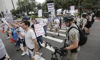Standing Guard - Officers keep the peace during a protest march.(Photo: AP Photo/Dave Martin)