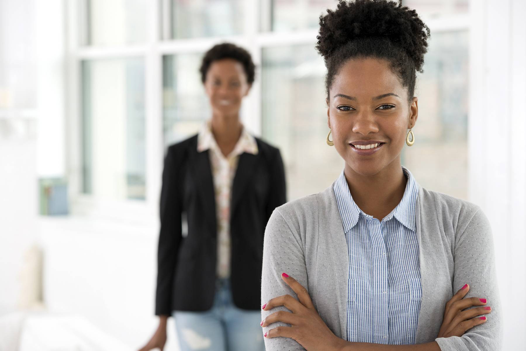 A business environment, a light airy city office. Business people. Two women. 