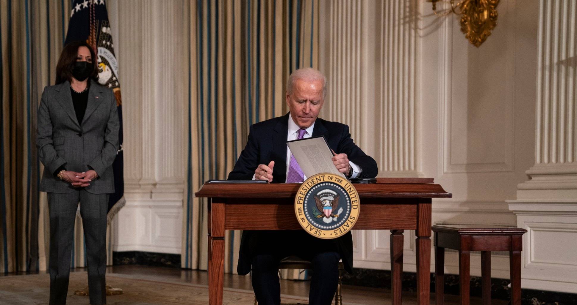 Vice President Kamala Harris looks on as President Joe Biden signs a series of executive orders on racial equity, in the State Dining Room of the White House, Tuesday, Jan. 26, 2021, in Washington. (AP Photo/Evan Vucci)