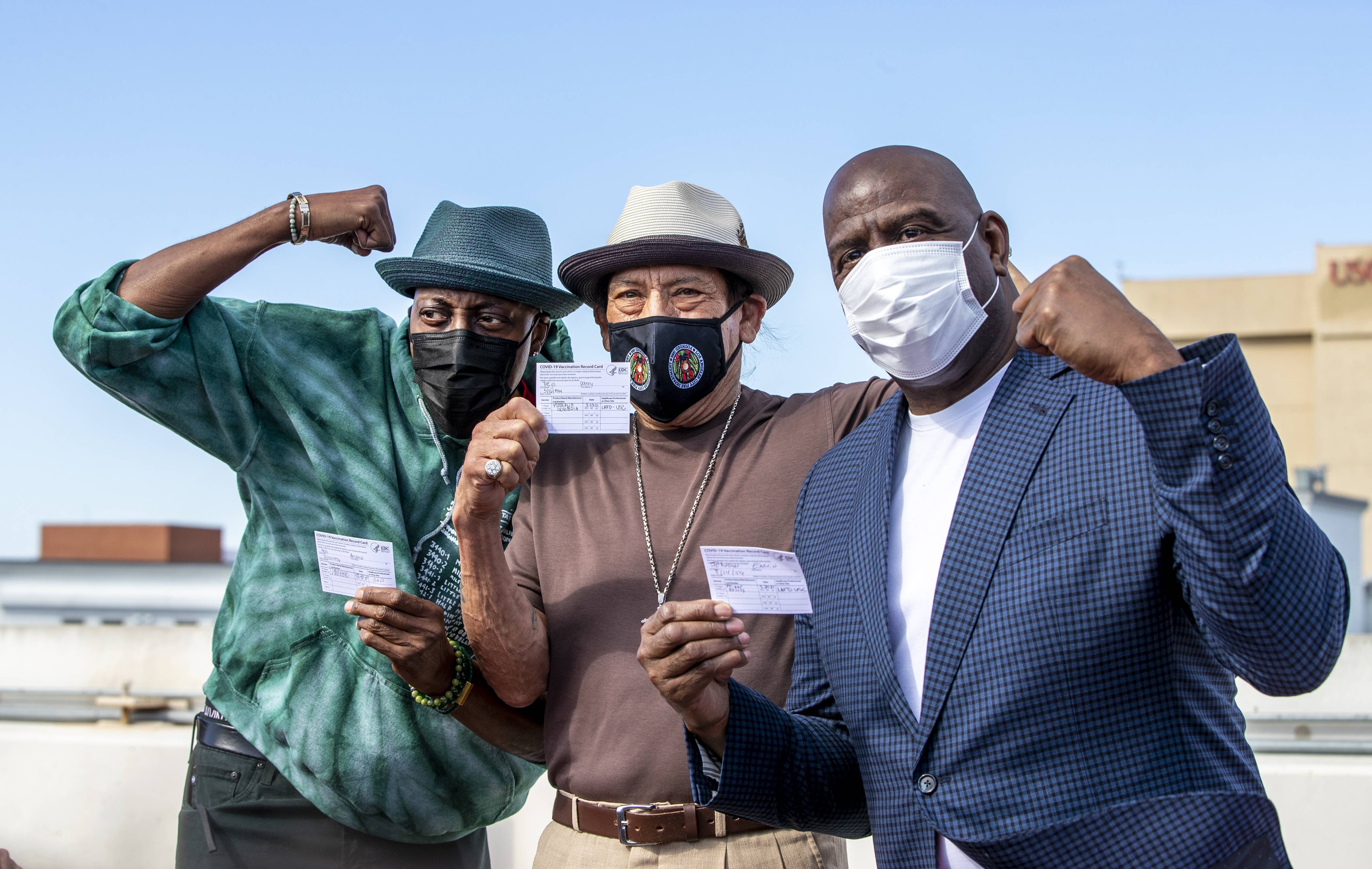 LOS ANGELES, CA - MARCH  24, 2021: Arsenio Hall, left, Danny Trejo and Magic Johnson pose for a photo after they all got vaccine shots  on the rooftop of parking structure at USC as a part of a vaccination awareness event at USC  on March 24, 2021 in Los Angeles, California. (Gina Ferazzi / Los Angeles Times via Getty Images)