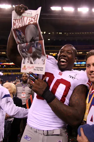 Extra! Extra! - Stellar Giants defender Jason Pierre-Paul enjoys some old-school print journalism. (Photo: Elsa/Getty Images)