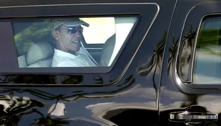 Home Sweet Home - Palm trees and a happy Obama are reflected in a window of his motorcade vehicle as he is driven to Marine Corps Base Hawaii to play golf.   (Photo: Carolyn Kaster/AP Photo)