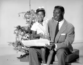 Natalie Cole A.K.A. “Sweetie” - Natalie Cole was born the second of five children to Nat “King” and Maria Cole. Singer Nat "King" Cole and his daughter Natalie Cole pose for a portrait session in front of a Christmas tree circa 1955. (Photo: Michael Ochs Archives/Getty Images)&nbsp;&nbsp;