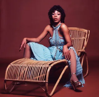 Strike a Pose - Here she wears statement heels and a blue halter dress with gold detailing to show off those toned shoulders for a 1976 portrait.(Photo: Michael Putland/Getty Images)