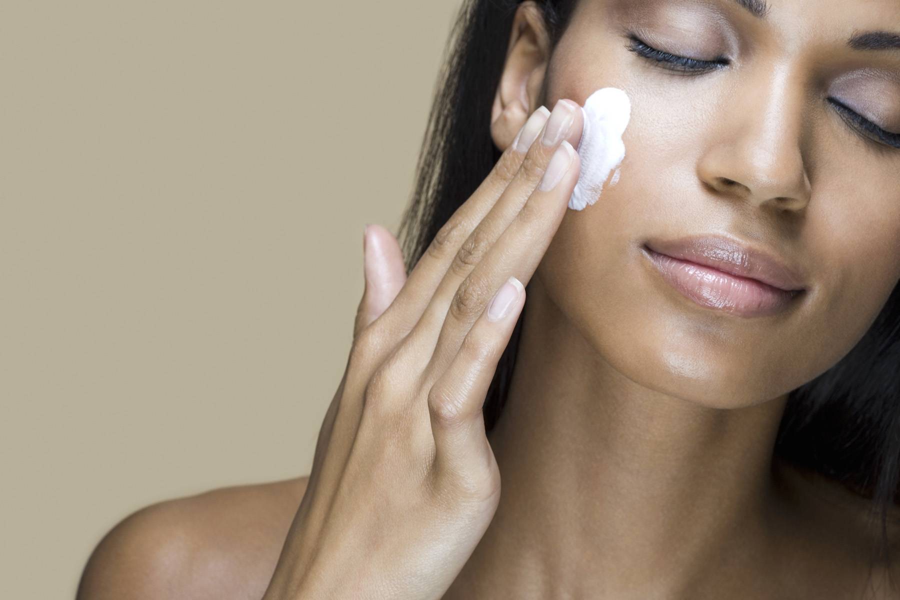 A woman rubbing moisturizer into her skin 