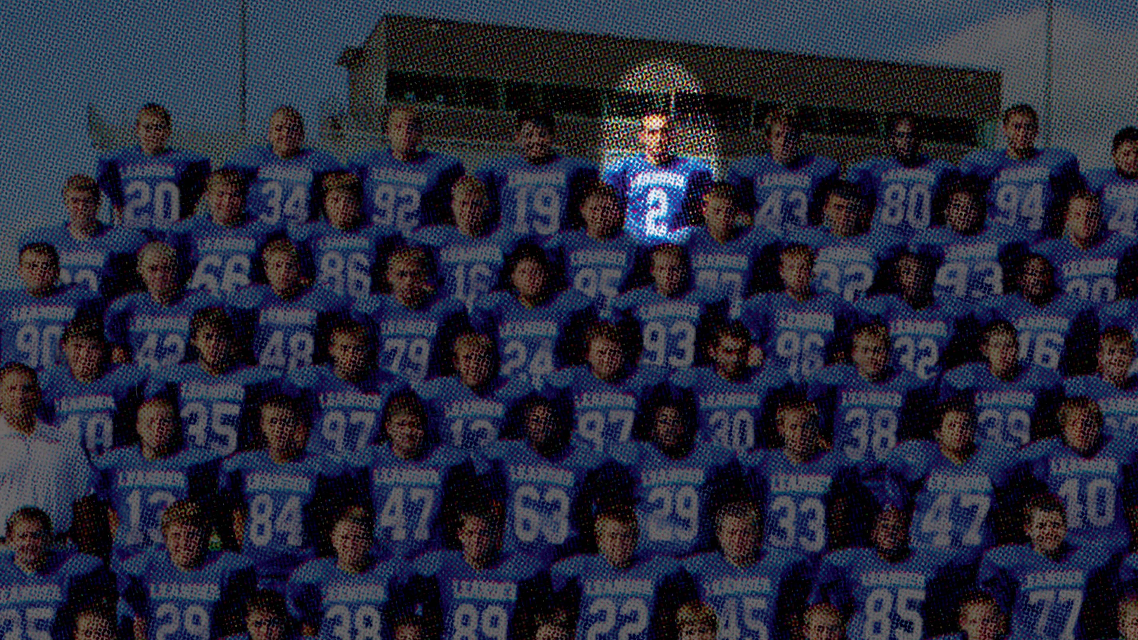 Grainy photo of a high school football team with one player in a spotlight