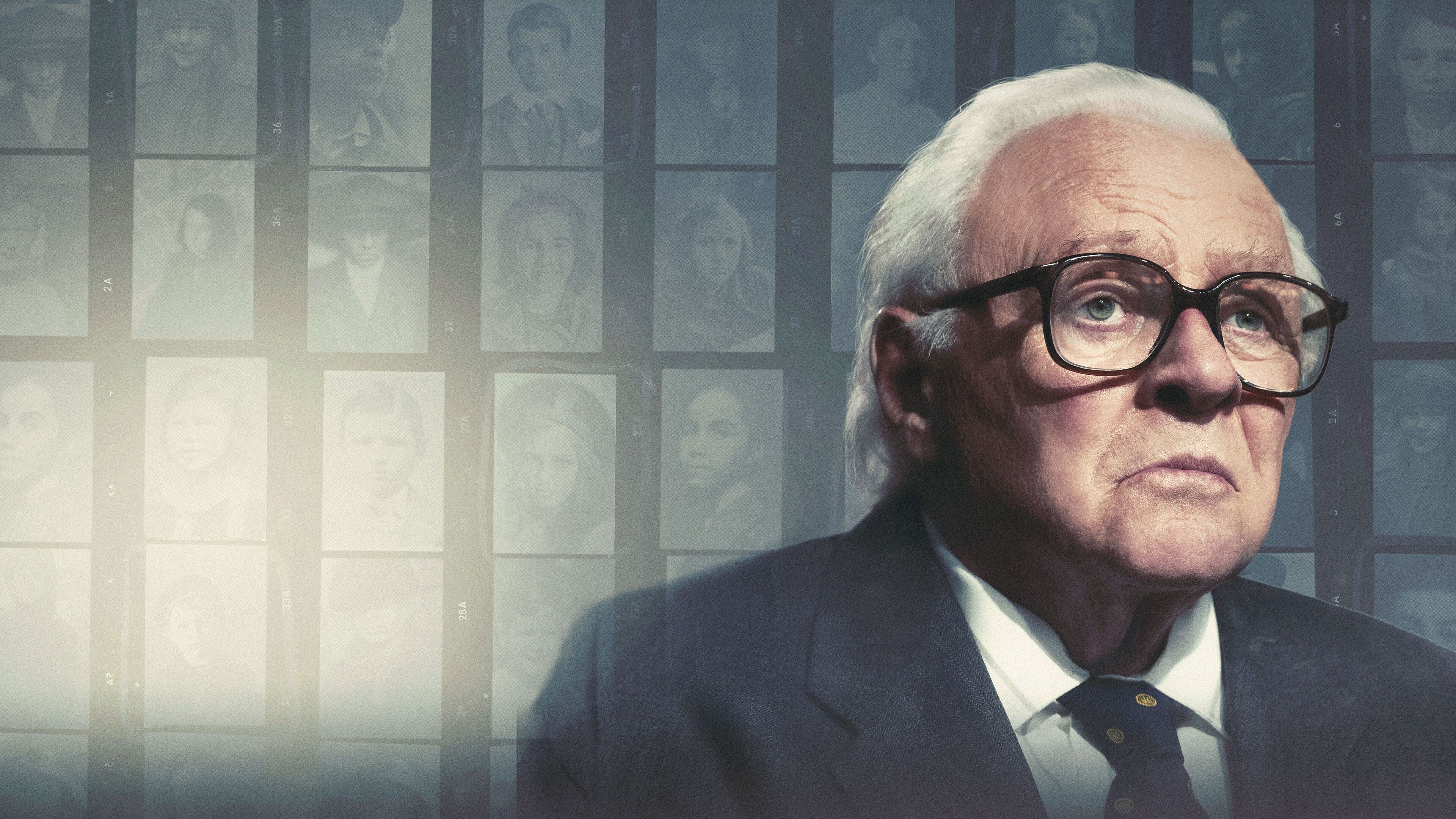 Anthony Hopkins as Sir Nicholas Winton, seated in front of a wall of old-fashioned photographs of children.